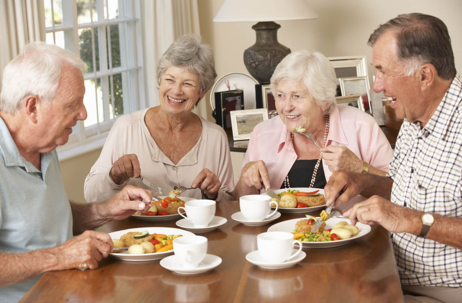 A group of happy seniors eating lunch together.