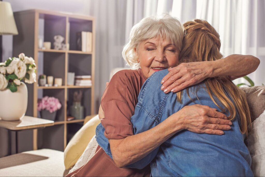 a senior hugging a loved one just after moving in a personal care community